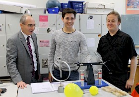 Foto: Daniel Schiller (Mitte) hat Spaß an der Influenzmaschine, Schulleiter Stefan Ade (links) und Physiklehrer Enrico Malz freuen sich mit dem Schüler über sein Weiterkommen in der Physikolympiade.