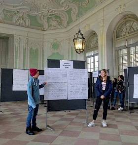 Levin (Privatgymnasium) und Lotta (Hebelgymnasium) präsentieren die Ergebnisse ihrer Gruppe im Schlussplenum.