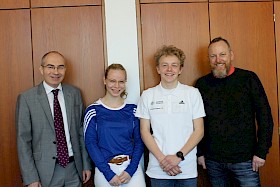 Schulleiter Stefan Ade (links) und Sportfachleiter Carsten Abbe (rechts) gratulieren den neu ausgebildeten Sportmentoren Hannah Gieser und Felix Abbe