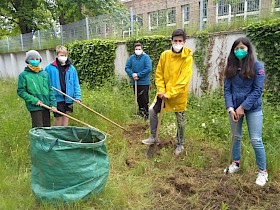 Bitte einmal recht bienenfreundlich: Anne, Birk und Eike Janson sowie Eliseo und Mati Carrasco Krämer bei der Gartenarbeit.