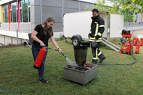 Referendarin Sandra Strupp lernt unter Aufsicht und Anleitung von Hannes Henn, Lehrer und Mitglied der freiwilligen Feuerwehr, einen Brand zu löschen.