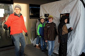 Michael Fröhlich lässt die Schüler im Dunkeltunnel genau hinschauen. Da ist die eine Puppe kaum zu entdecken, während die andere gut zu sehen ist. Warum?