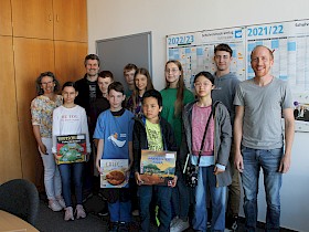 Elternvertreterin Elke Birkel, Schulleiter Gundolf March und Mathematiklehrer Florian Seitz freuen sich, zwölf erfolgreichen Schülern Knobelspiele und Bücher, die sie beim Mathematik-Wettbewerb „Känguru“ gewonnen haben, überreichen zu können.