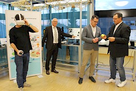 Yasin Cinar (rechts) gehört zu den Hauptsponsoren der „Woche des Wassers“. Hier lässt er sich von dem Chemielehrer und Initiator der Themenwoche Hannes Steffen Henn (daneben) erklären, wie Schadstoffe an Mikroplastik, verdeutlicht durch den Tennisball, andocken und so in den Körper gelangen. Prof. Andreas Fath vergrößert am Computerbildschirm den Reifenabrieb, der zu einem großen Teil für Mikroplastik in der Natur verantwortlich ist. Projektleiter Benjamin Heberling (links) testet die virtuelle Brille.