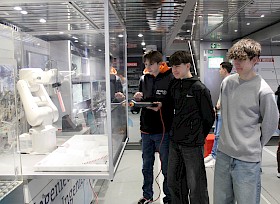Im „Discover Industry“-Truck gibt es viele Stationen zum Ausprobieren neuer Technik: Hier steuern Timo Walburg, Berat Gürleyen und Luke Danchi einen Roboterarm.