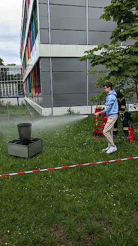 Tim (J1) löscht die Flammen mit einem Übungsfeuerlöscher. (Bild: Lukas Wilhelm, J1)