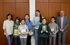 Marion Strommer (Organisatorin des Vorlesewettbewerbs)(links) freut sich mit Schulleiter Stefan Ade (rechts) über die Begeisterung der Vorlese-Sieger für Bücher: Lenn Förster, Emelie Kulagin, Valeria Kulikov, Schulsiegerin Emilia Bihr, Maya Lübbehusen und Jonathan Steger.