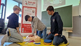 Lilli Manhart und Marcel Kaufka (Klasse 9) trainieren an einer Puppe die Wiederbelebungsmaßnahmen. Trainer Leon Peetz von First Aid For All achtet auf die korrekte Durchführung.